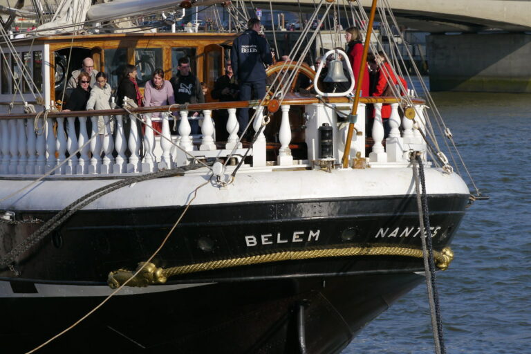 Photo représentant Le Belem au premier plan. L'équipe pédagogique est présente sur l'arrière du trois-mâts, appelé la poupe, avec les stagiaires en formation.